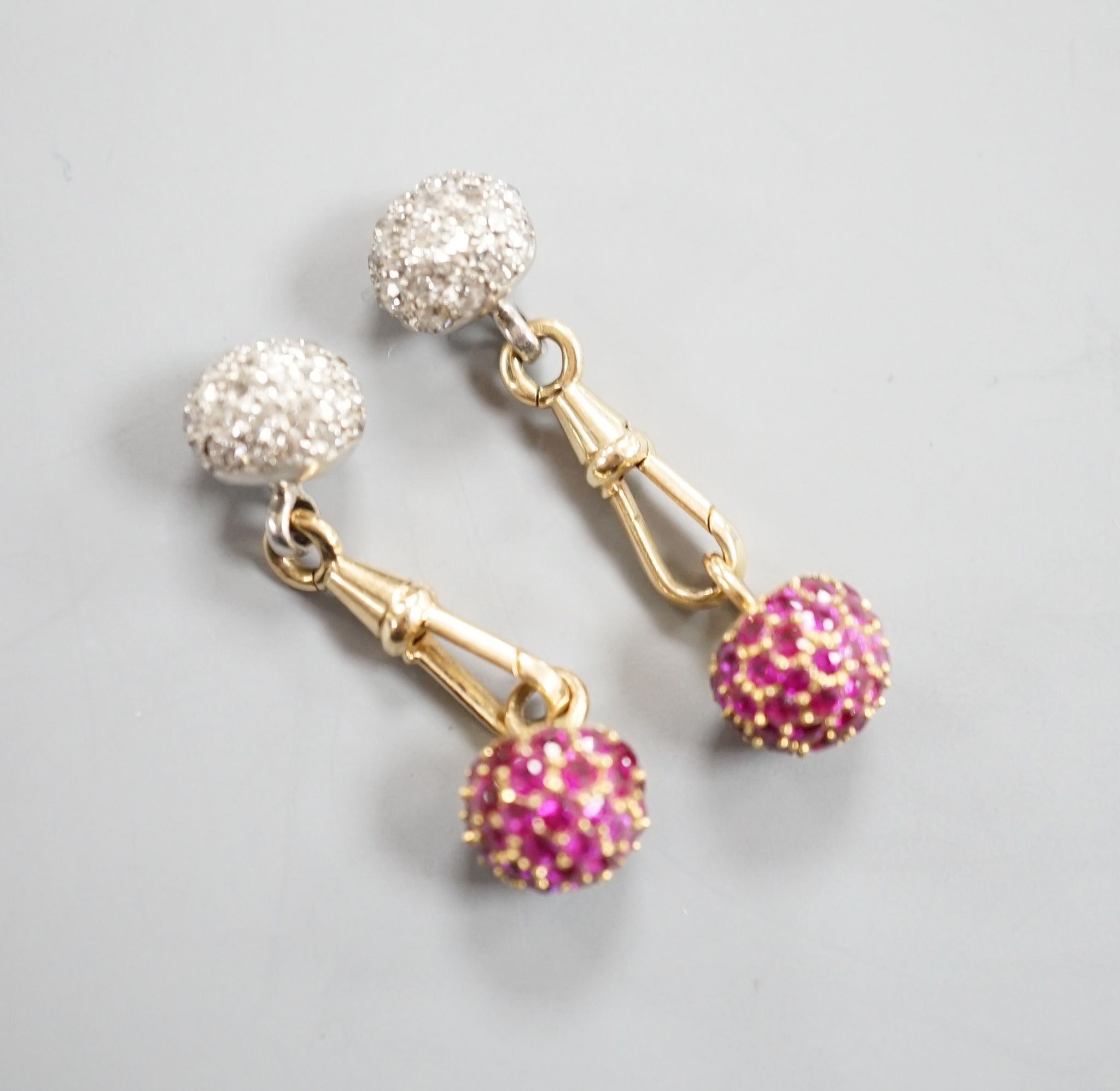 A pair of yellow metal and pave set ruby and diamond cufflinks (adapted), gross weight 10 grams.
